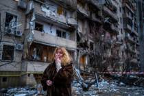 Natali Sevriukova reacts next to her house following a rocket attack the city of Kyiv, Ukraine, ...
