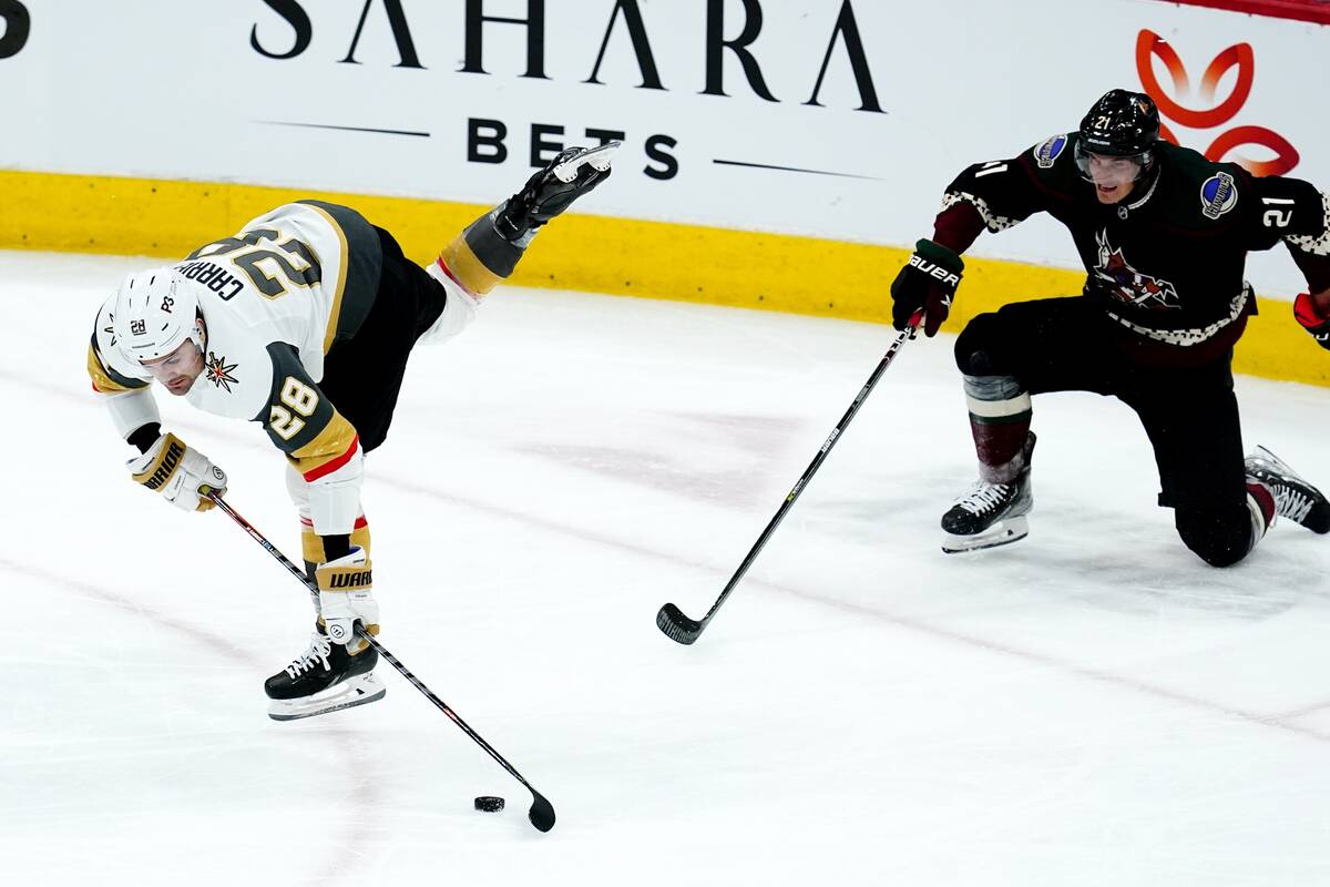 Vegas Golden Knights left wing William Carrier (28) tries to keep control of the puck as Arizon ...