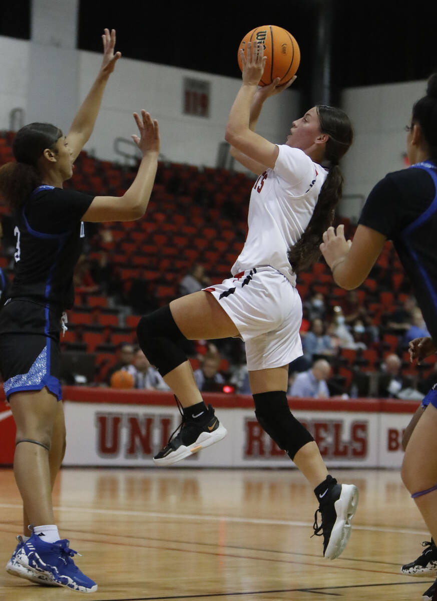 Las Vegas High School's Layla Faught (1) goes to the basket as Desert Pines High School's Tati ...