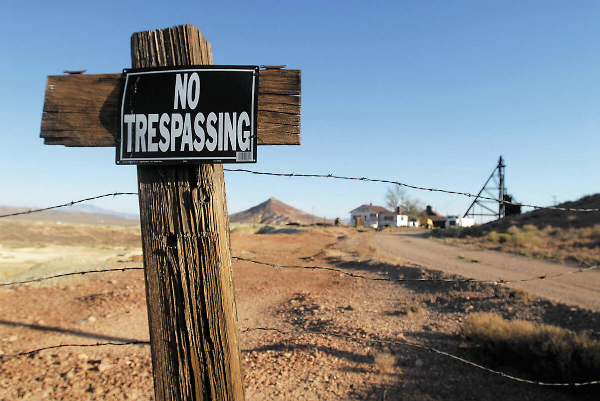 A barbed wire fence posted with a no trespassing sign is shown on the outskirts of the one-time ...