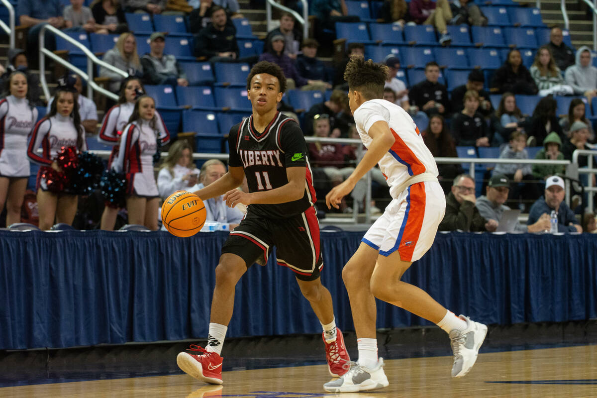 LibertyÕs Christopher Nwuli Dedan Thomas Jr. brings the ball up the court guarded by John ...