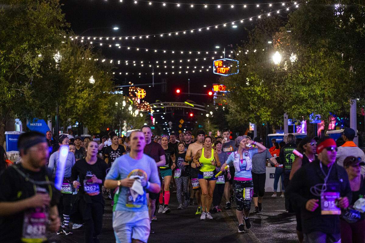 Participants run along Fremont Street during the Rock ‘n’ Roll Las Vegas half mar ...
