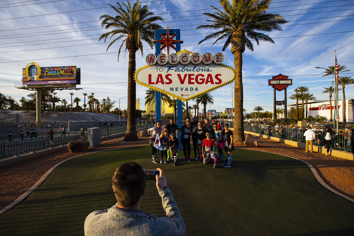 Participants stop for a photo at the “Welcome to Fabulous Las Vegas” sign during ...