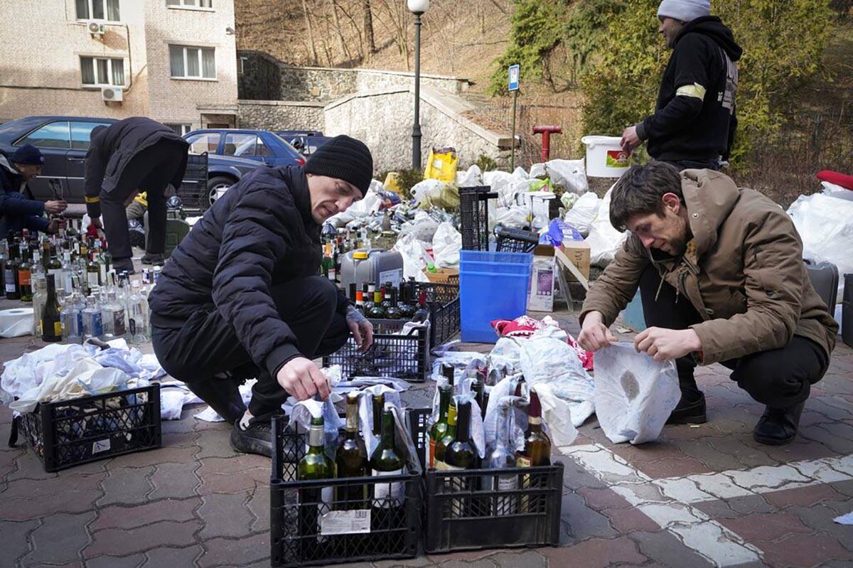 Members of civil defense prepare Molotov cocktails in a yard in Kyiv, Ukraine, Sunday, Feb. 27, ...