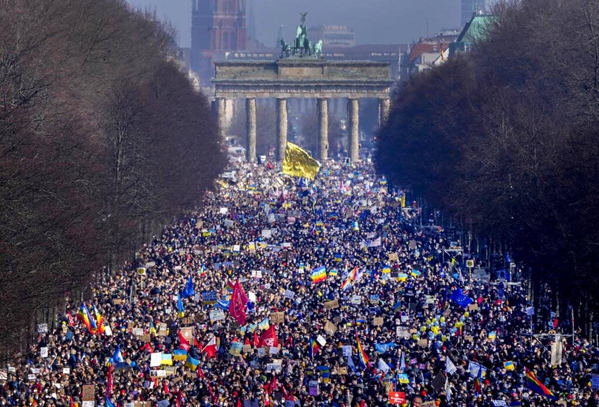 People walk down the bulevard 'Strasse des 17. Juni' ahead of a rally against Russia's invasion ...