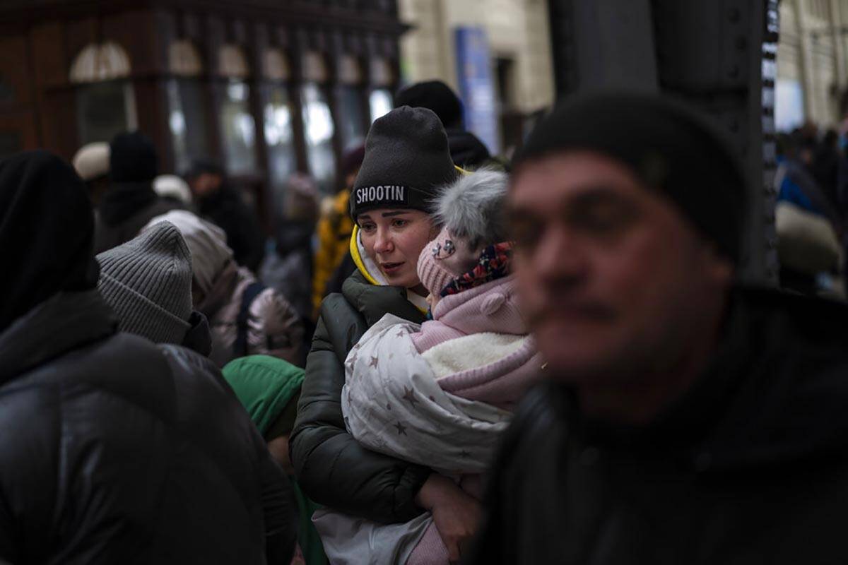 A Ukrainian family waits for a train inside Lviv railway station, Sunday, Feb. 27, 2022, in Lvi ...