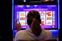 A gambler smoking while playing a slot machine at the Ocean Casino Resort in Atlantic City N.J. ...