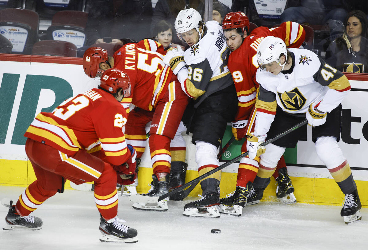Vegas Golden Knights' Mattias Janmark, center, and Nolan Patrick, right, battle for the puck wi ...