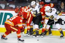 Vegas Golden Knights' Mattias Janmark, center, and Nolan Patrick, right, battle for the puck wi ...