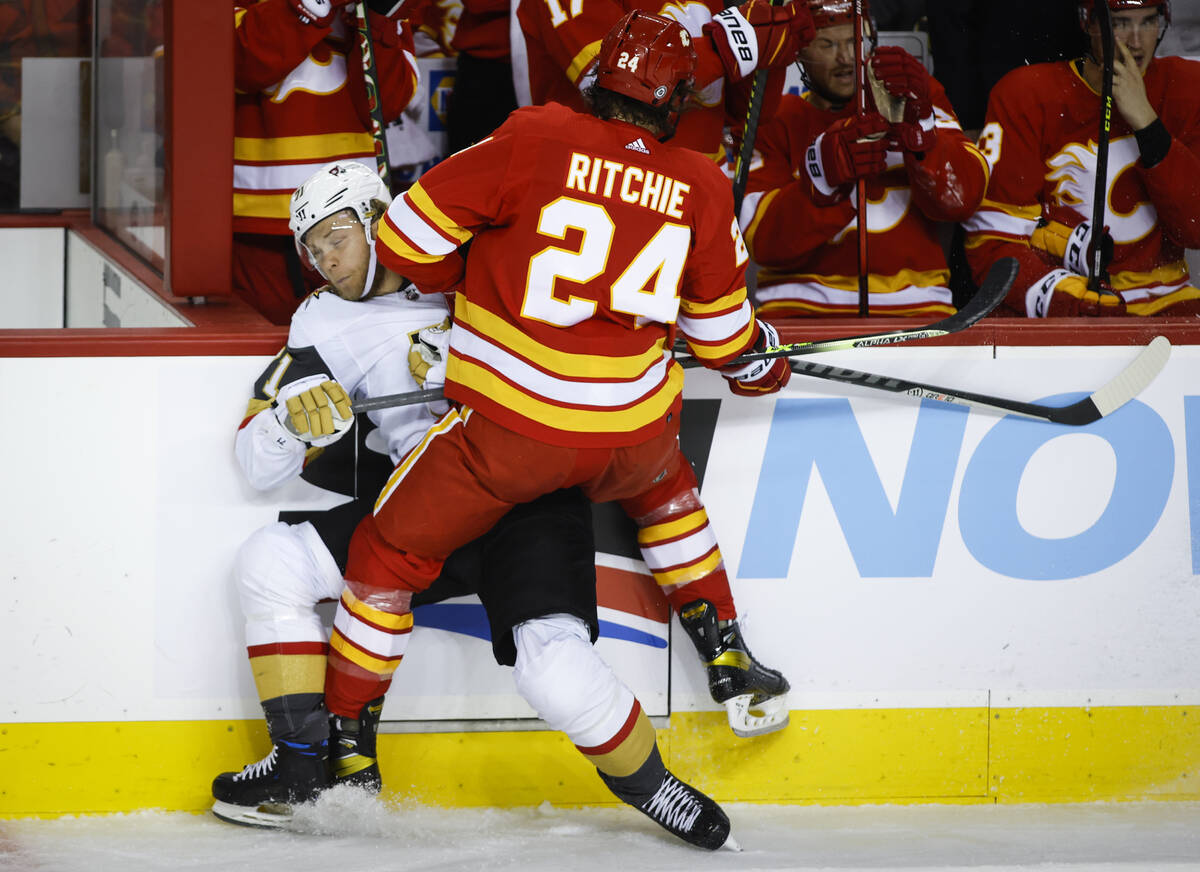 Vegas Golden Knights' William Karlsson, left, is checked by Calgary Flames' Brett Ritchie durin ...