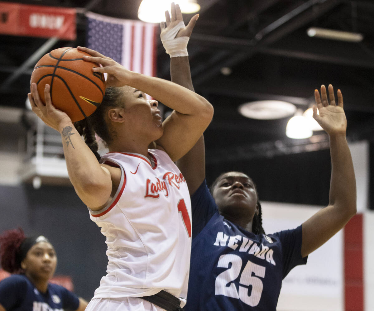 UNLV Lady Rebels forward Nneka Obiazor (1) drives baseline over Nevada Wolf Pack guard Nia Alex ...