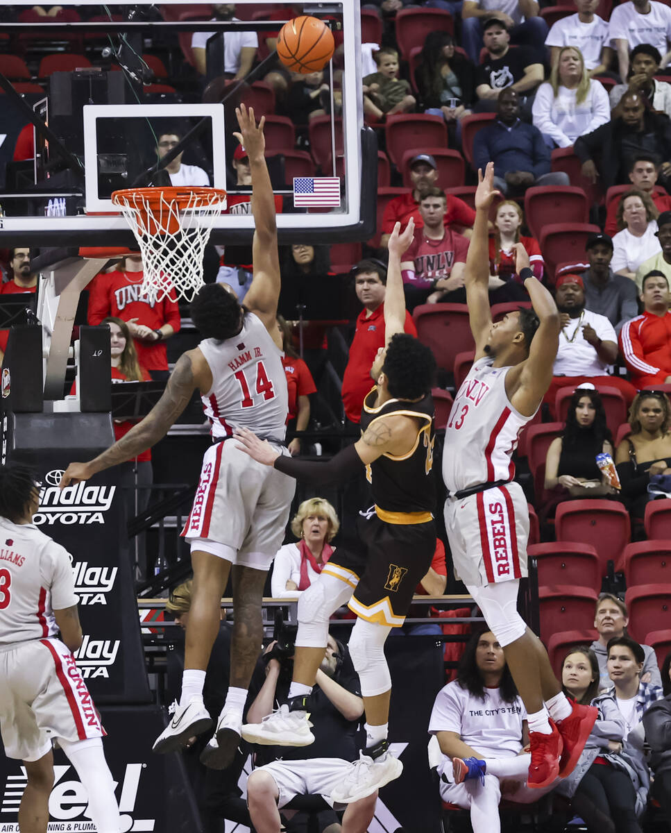 UNLV Rebels forward Royce Hamm Jr. (14) looks to block a shot from Wyoming Cowboys forward Jere ...