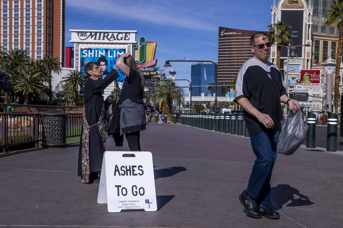 Deacon Bonnie Polley, left, applies ashes to passers-by for Ashes to Go on Ash Wednesday from C ...