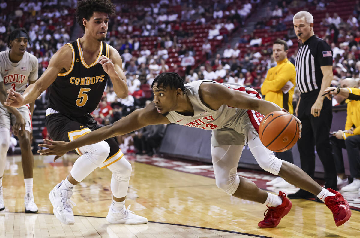 UNLV Rebels guard Bryce Hamilton (13) drives the ball under pressure from Wyoming Cowboys guard ...