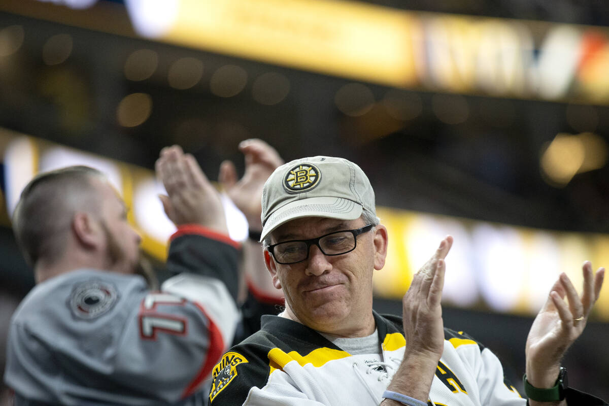 Bruins fans celebrate after their team scored a goal during the first period of an NHL hockey g ...