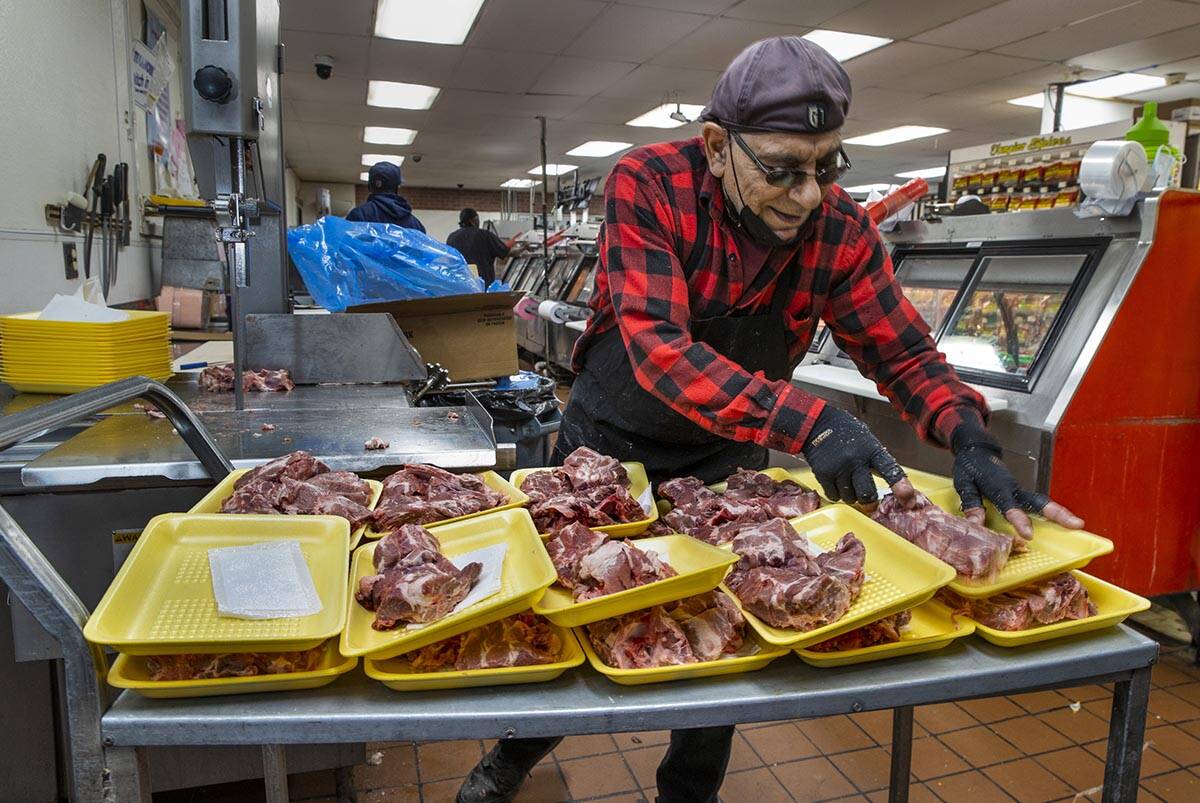 Tony Haber cuts up fresh pork for their meat counter at Mario's Westside Market looking for a m ...