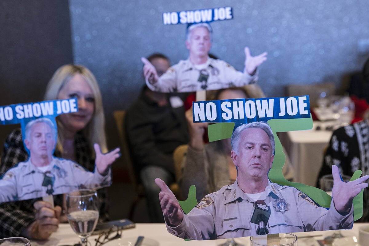 Pam Bennets, left, and Judy Leslie, center, hold cutouts of Nevada Republican governor candidat ...