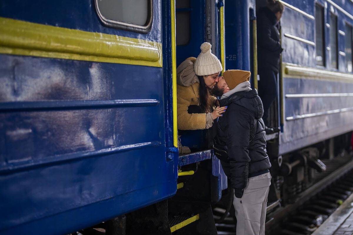Stanislav, 40, kisses his wife Anna, 35, on a train to Lviv as they say goodbye at the Kyiv sta ...