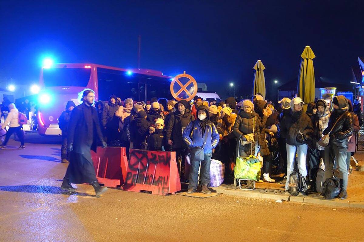 People fleeing form Ukraine wait to board a bus at the border crossing in Medyka, Poland, Frida ...