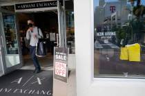For sale and hiring signs are displayed at an Armani Exchange store, Friday, Jan. 21, 2022, in ...