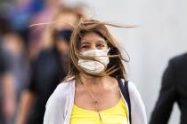 People brave high winds on the Strip on Monday, Oct. 11, 2021, in Las Vegas. A sunny sky with w ...