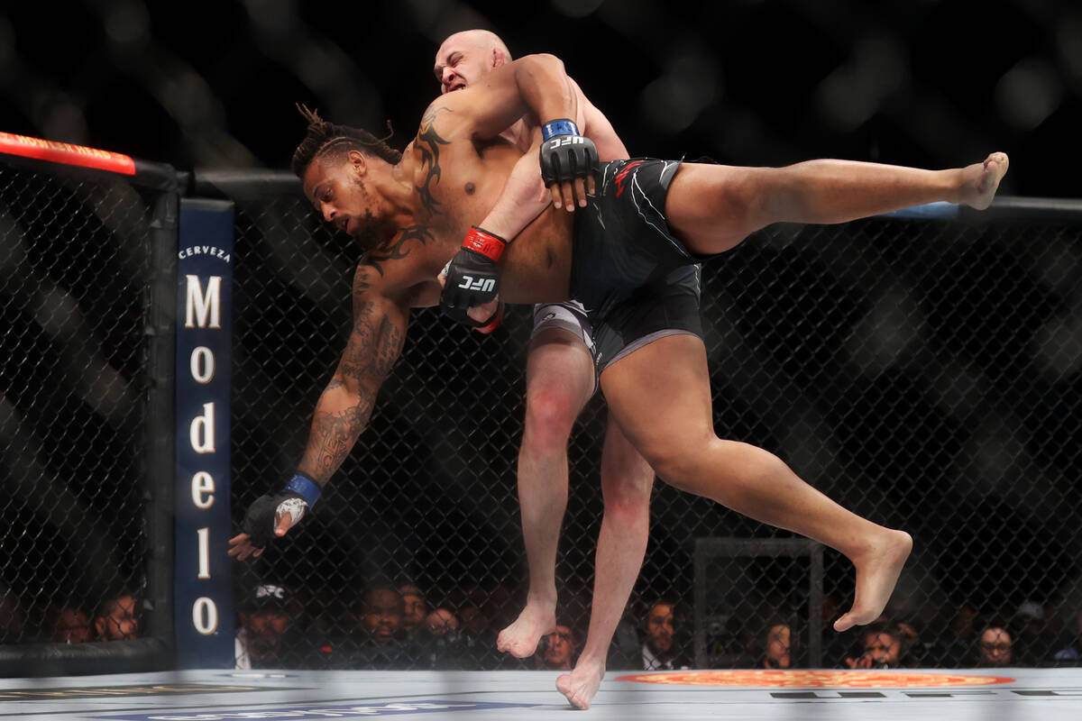 Serghei Spivac, rear, takes down Greg Hardy in the first round of the UFC 272 heavyweight bout ...