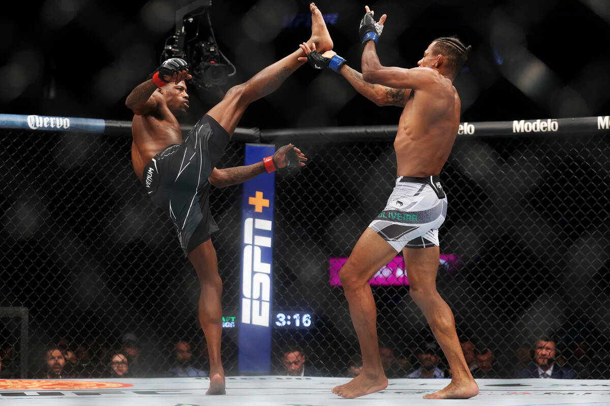 Kevin Holland, left, kicks Alex Oliveira in the first round of an UFC 272 welterweight bout at ...