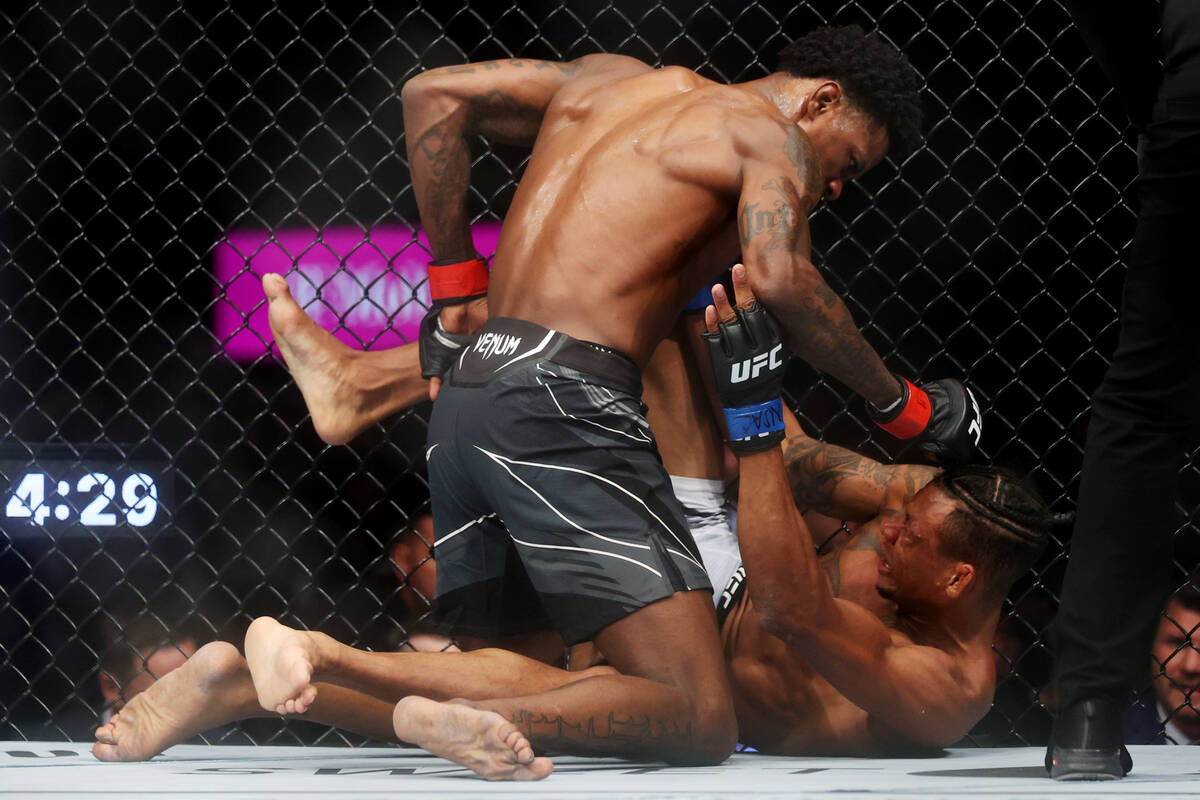 Kevin Holland, left, finishes Alex Oliveira in the second round during an UFC 272 welterweight ...
