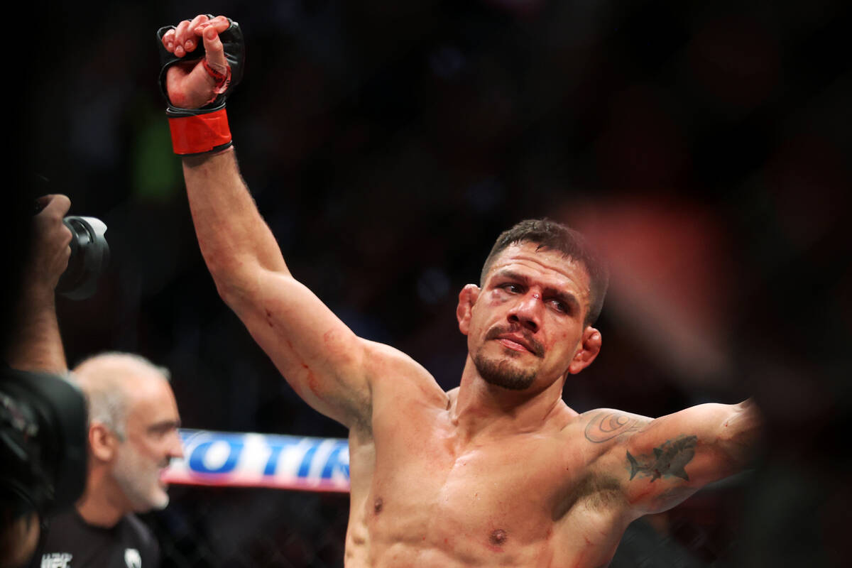 Rafael Dos Anjos raises his arm in victory after his unanimous decision win against Renato Moic ...