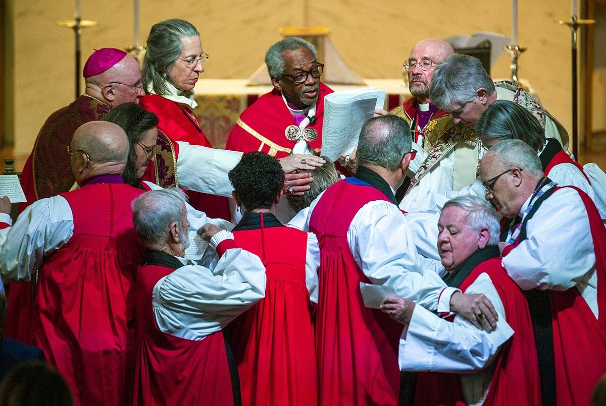 The Rev. Elizabeth Bonforte Gardner, center, has hands laid on her while presiding Bishop Micha ...