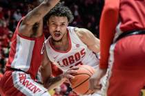 New Mexico's Jaelen House, center, drives against UNLV defenders, including Michael Nuga, left, ...