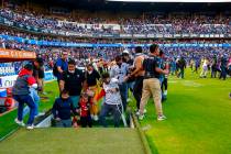 Fans of Queretaro and Atlas clash during a Mexican soccer league match at the Corregidora stadi ...