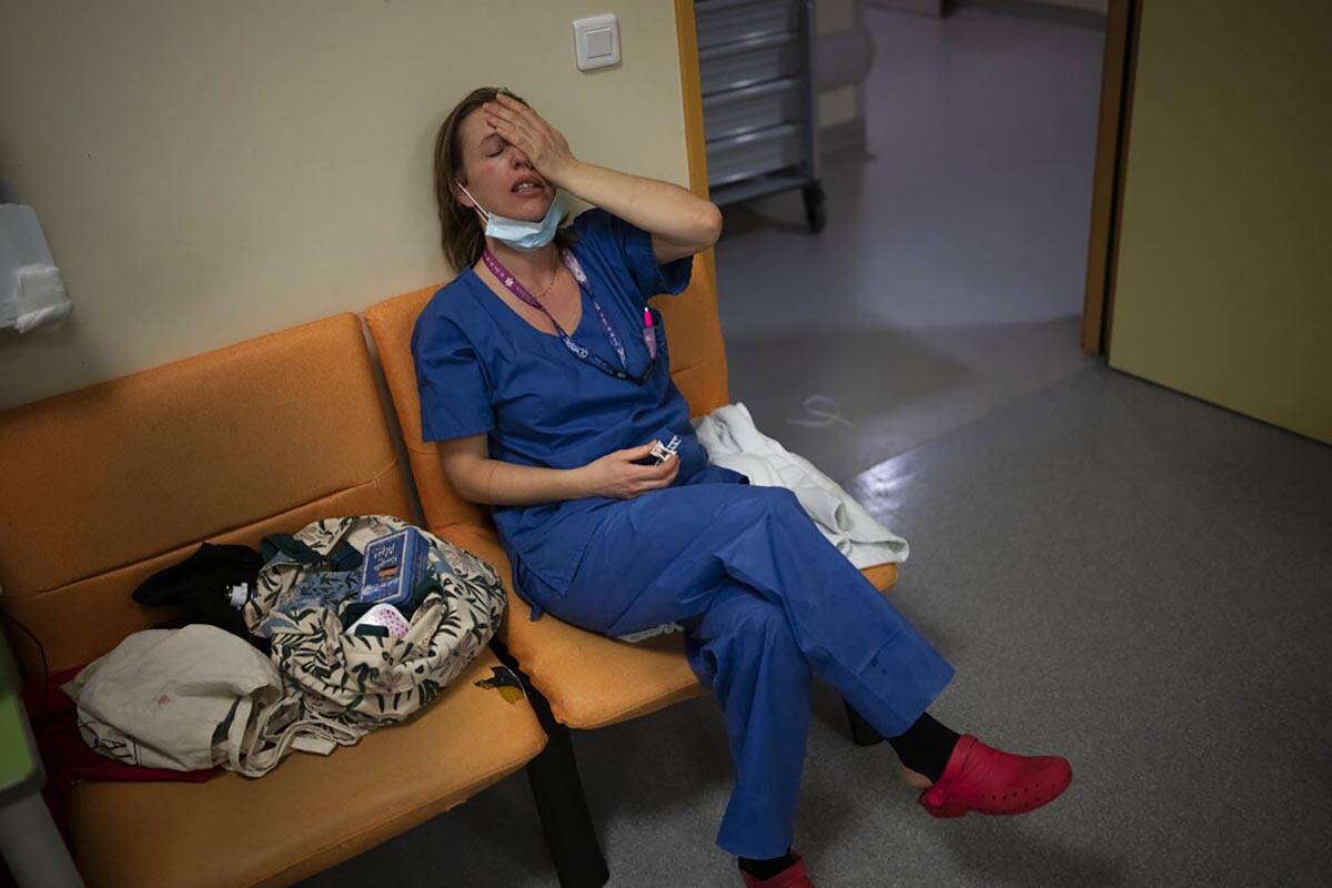 FILE - Nurse Marie-Laure Satta pauses during her New Year's Eve shift in the COVID-19 intensive ...