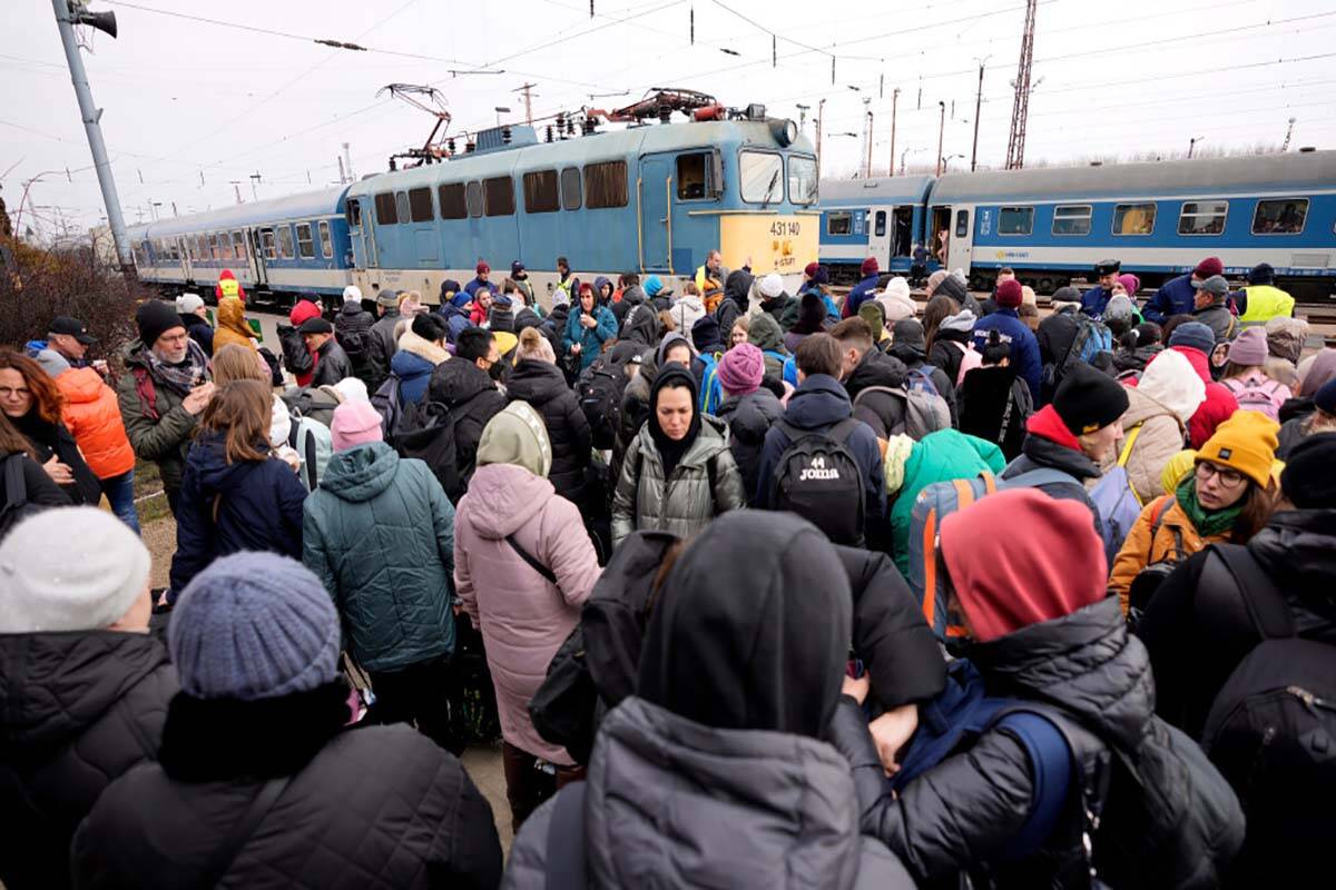 People, who have fled from Ukraine, wait to board a train traveling to Budapest at the train st ...