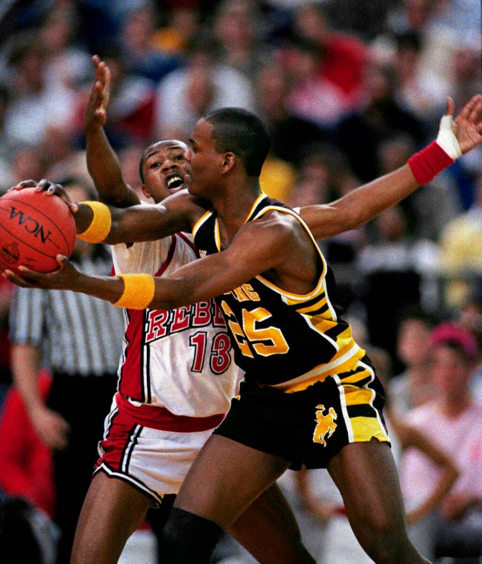 University of Nevada-Las Vegas guard Freddie Banks (13) gets a hand in the face of Wyoming guar ...