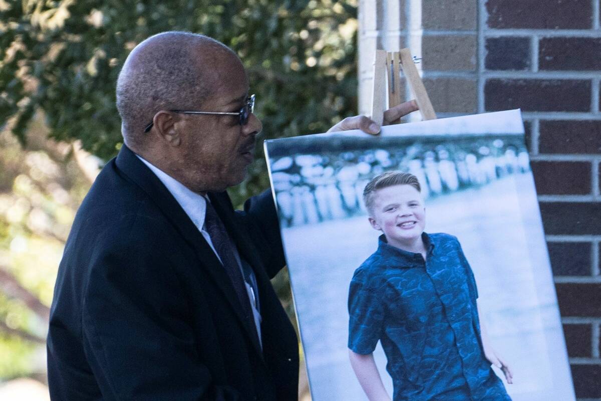 A photograph of Rex Patchett, 13, is carried into Church of Jesus Christ of Latter-day Saints o ...
