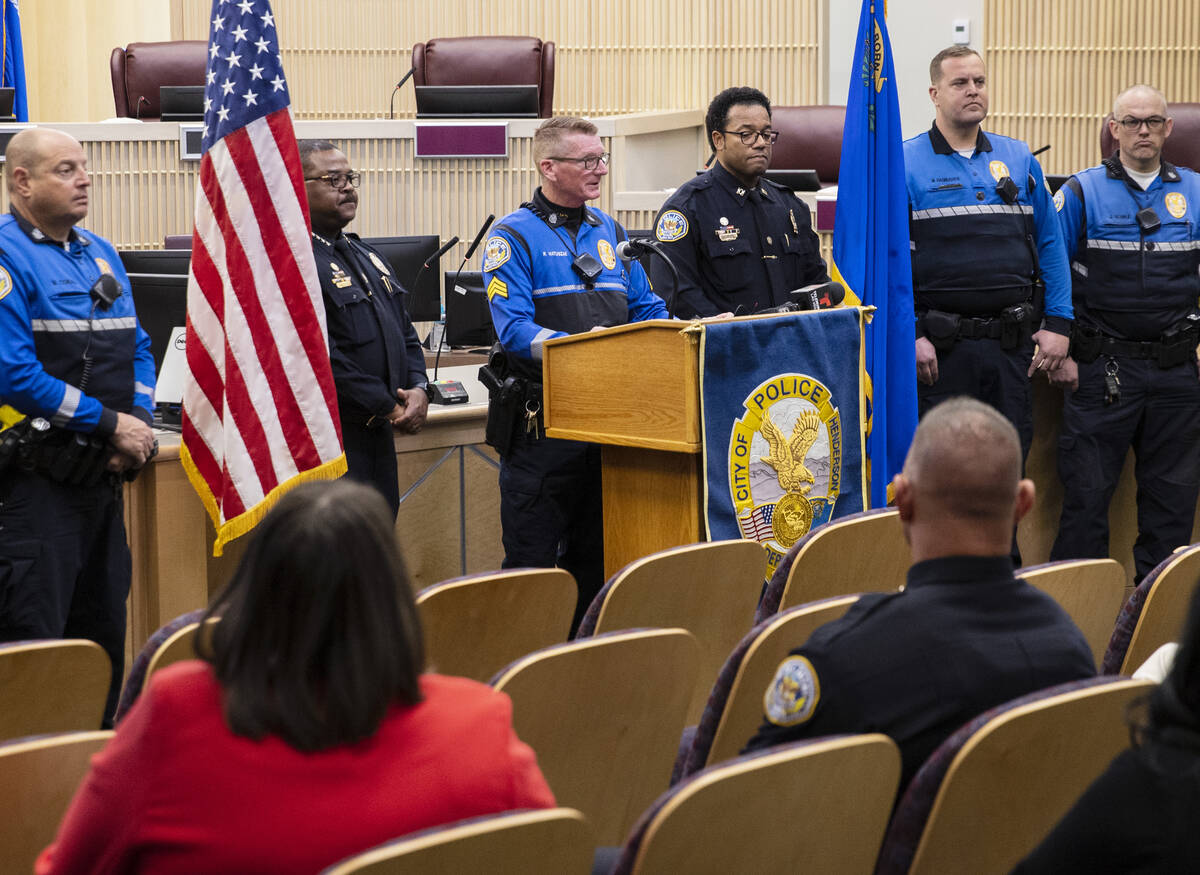 Henderson Police Department Sgt.. Roger Matuszak, center, flanked by Chief Thedrick Andres, lef ...