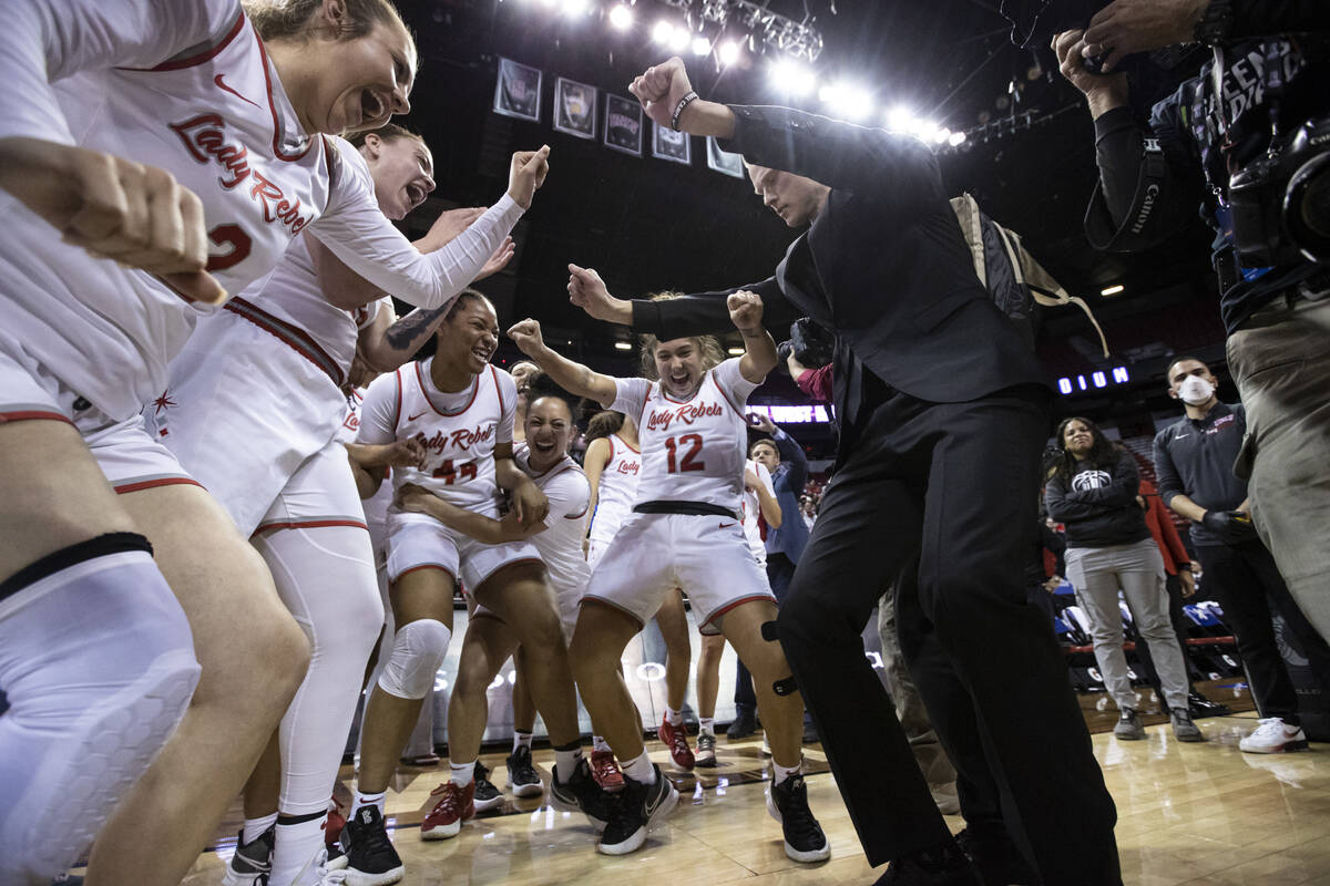 The UNLV Lady Rebels celebrate with assistant coach Roman Owen, right, after defeating the Colo ...