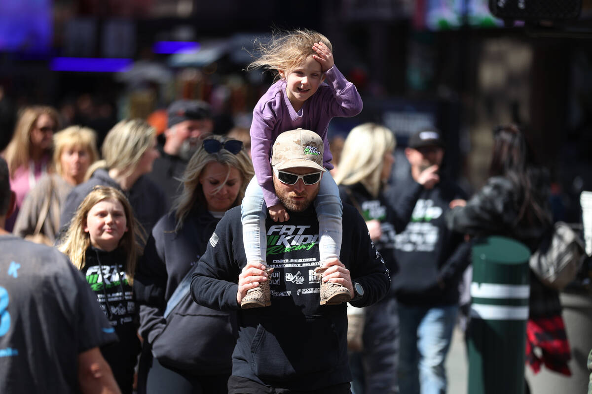 People walk on Fremont Street in Las Vegas during a windy day, Thursday, March 10, 2022. (Erik ...