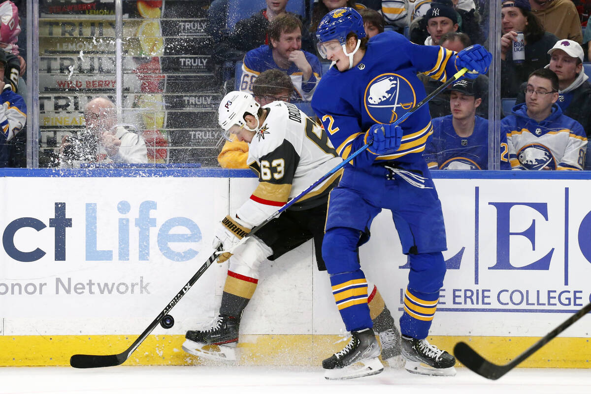 Vegas Golden Knights right wing Evgenii Dadonov (63) is checked by Buffalo Sabres right wing Ta ...
