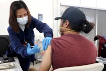 Maria Mendoza gives a shot to Javier De La Torre of Las Vegas at a COVID-19 vaccination station ...