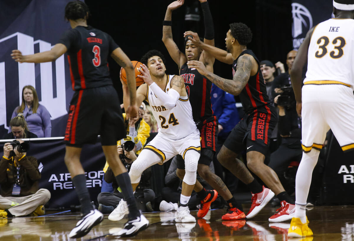 Wyoming Cowboys guard Hunter Maldonado (24) works the ball around UNLV Rebels guard Keshon Gilb ...