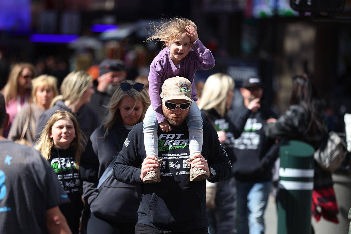 People walk on Fremont Street in Las Vegas during a windy day, Thursday, March 10, 2022. Friday ...