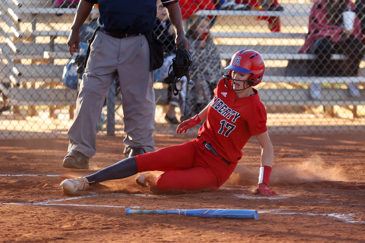 Liberty’s Jesse Farrell (17) slides home for a score against Coronado during a softball ...