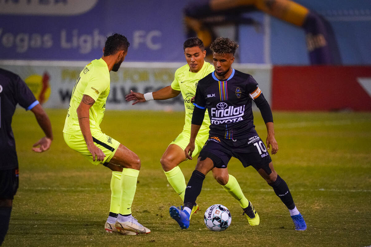 Danny Trejo dribbles the ball against a pair of defenders. (LV Lights Communications)