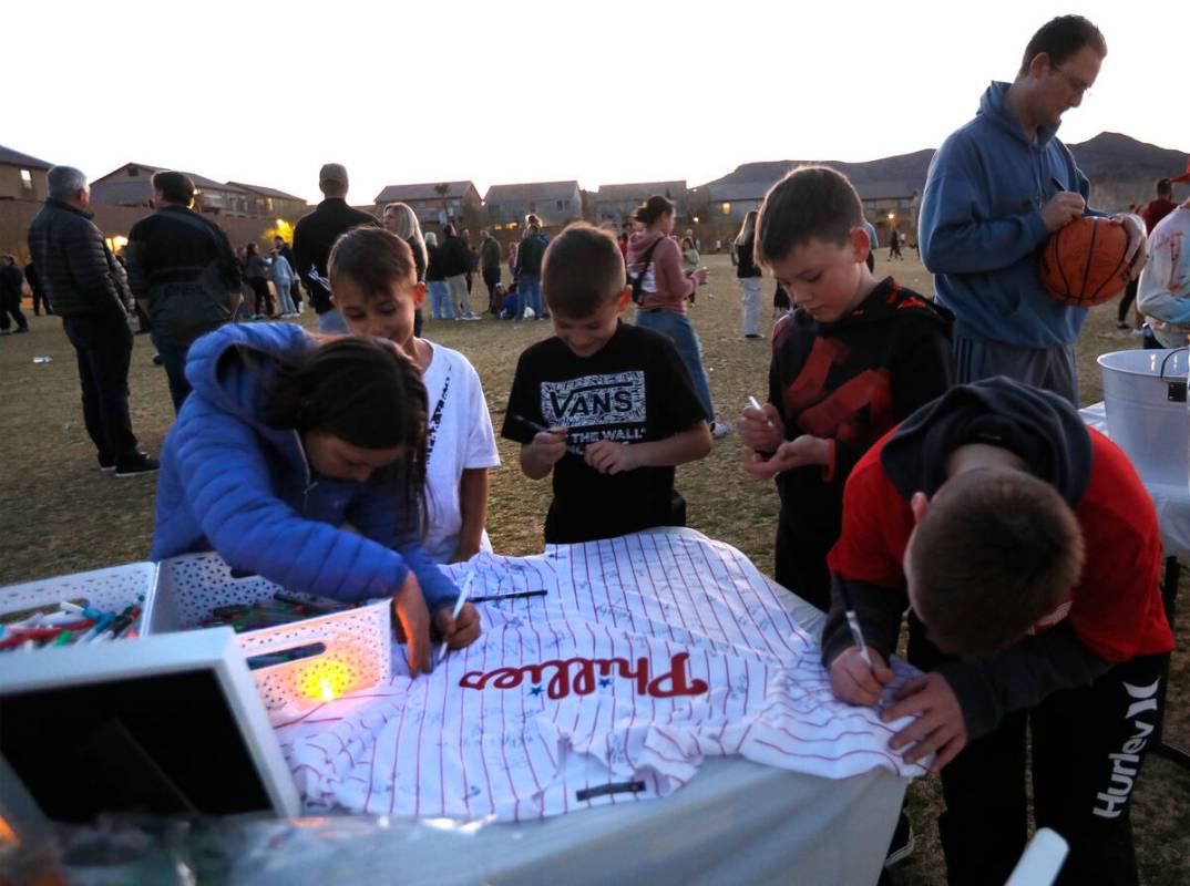 Children including Ruby Rehrer, 10, of Henderson sign a shirt for Rex Patchett, Friday, March 1 ...