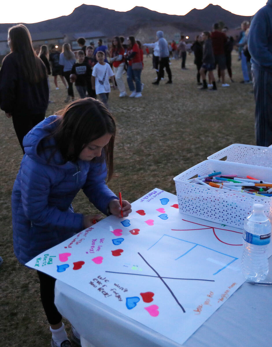 Ruby Rehrer, 10, of Henderson signs a poster for Rex Patchett, Friday, March 11, 2022, during a ...