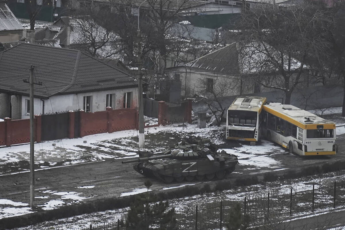A Russian army tank moves through a street on the outskirts of Mariupol, Ukraine, Friday, March ...