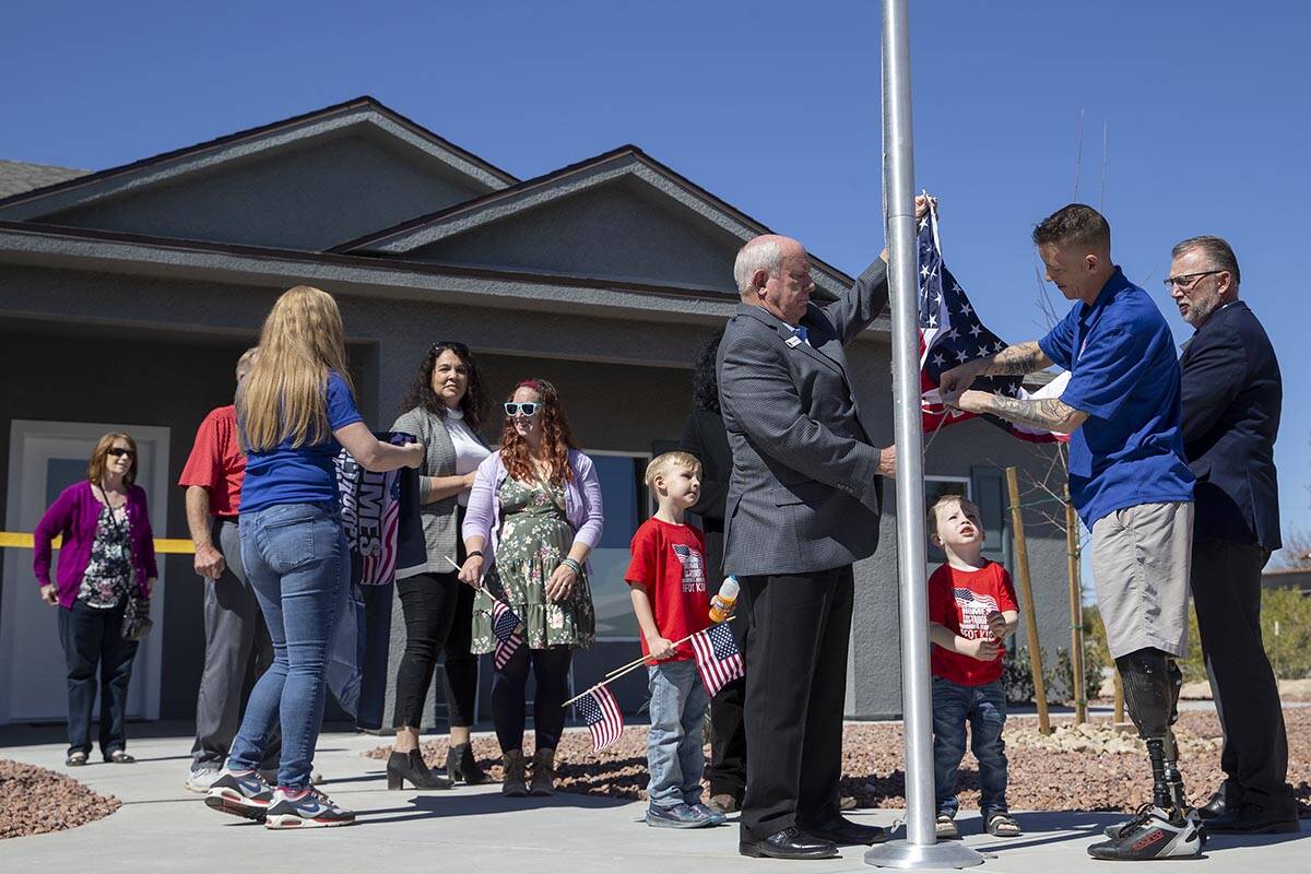 Army Sergeant Adam Poppenhouse, second from right, and Homes for Our Troops CEO Tom Landwermeye ...