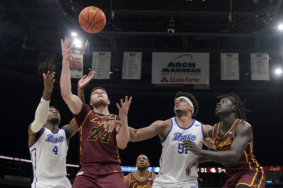 Loyola of Chicago's Tate Hall (24) and Drake's ShanQuan Hemphill (4) reach for a rebound as Dra ...